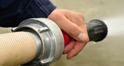 A hand holding and testing the fire hose.