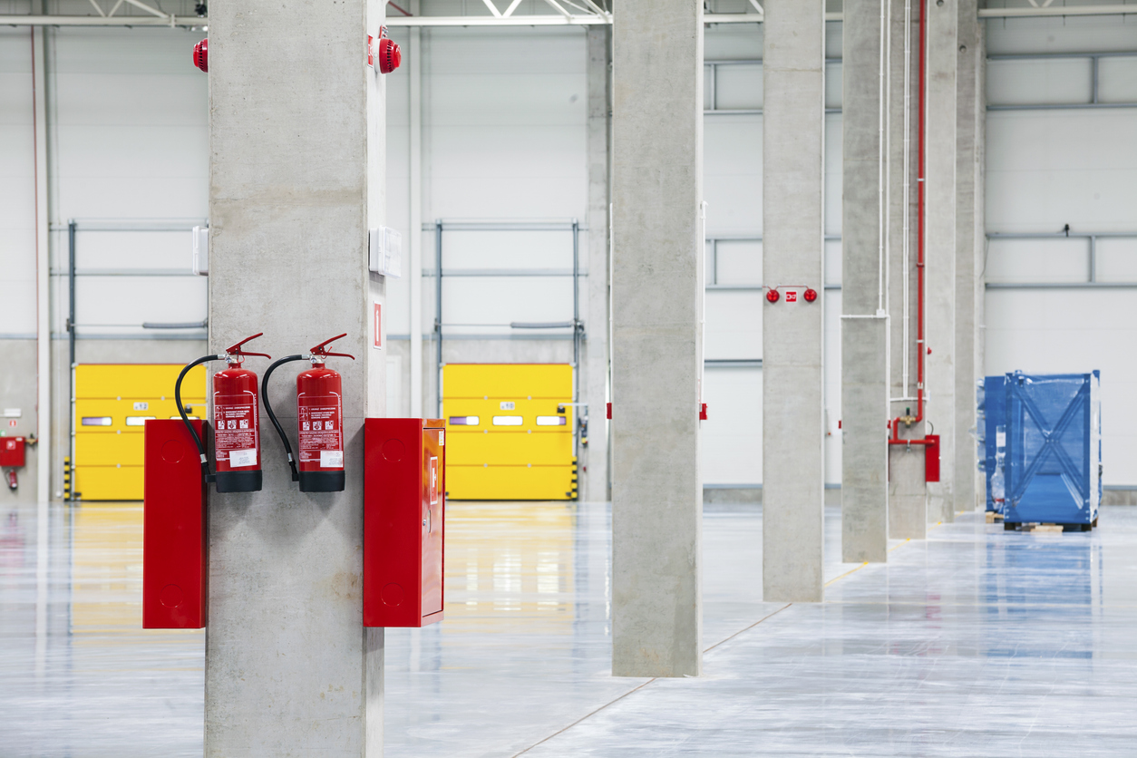Modern, Empty, Brand New, Huge Storehouse with a fire extinguisher on post.
