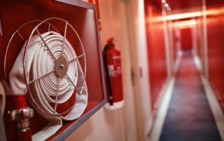 Fire extinguisher and hose reel in corridor.